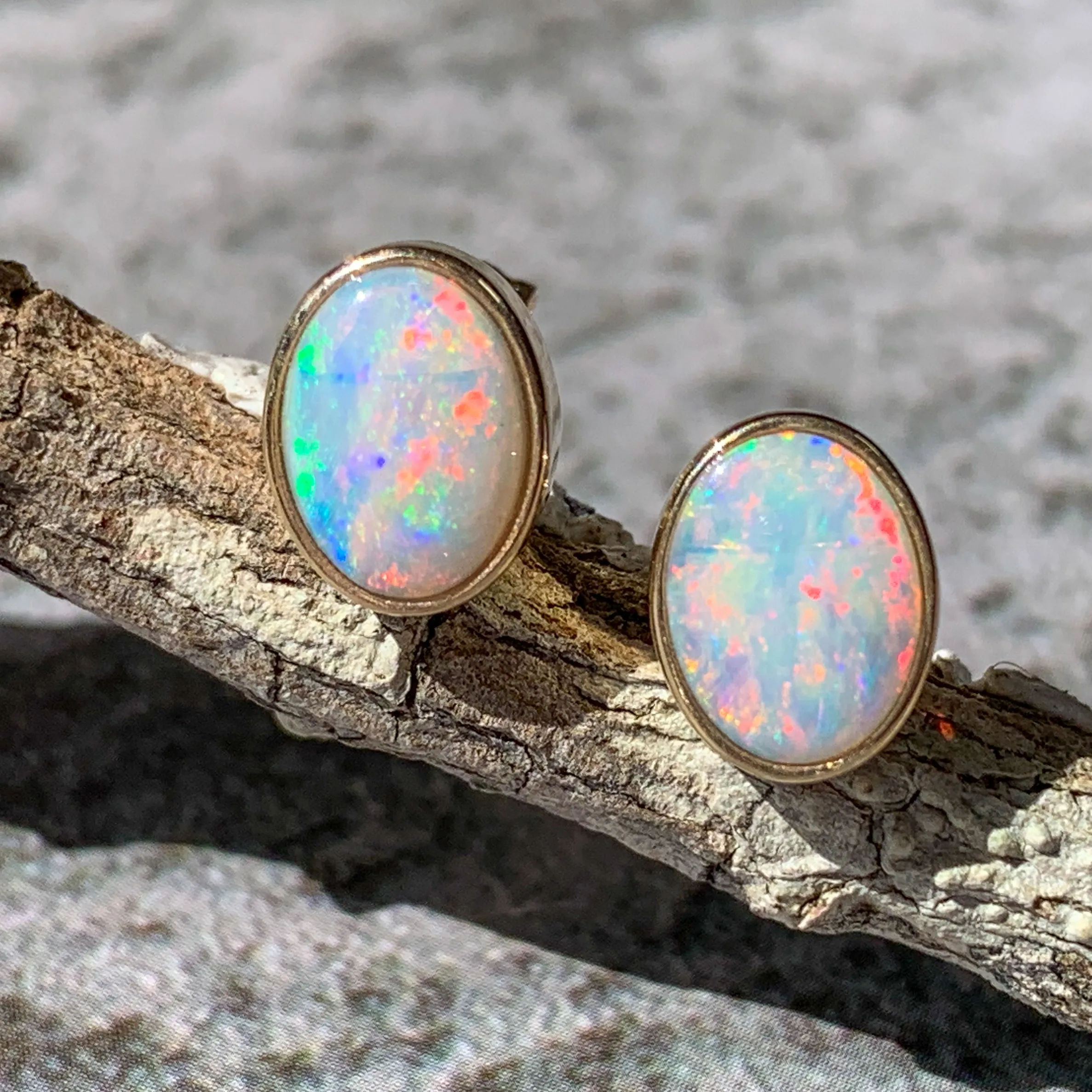One pair of 9kt Yellow Gold Light Opal earring studs 7x5mm bezel set