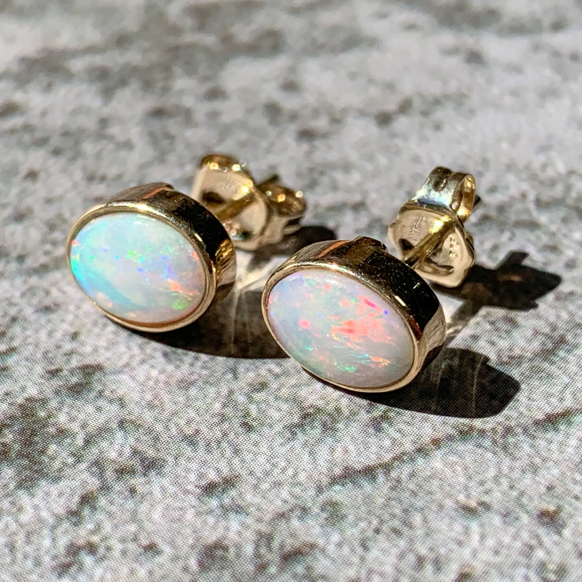 One pair of 9kt Yellow Gold Light Opal earring studs 7x5mm bezel set